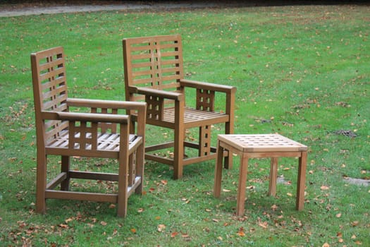 Wooden lawn chairs and table on the grass