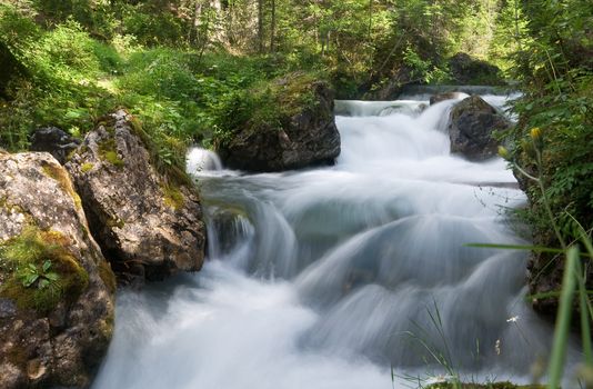 beautiful nature scene with river and waterfall at summer in val di Fassa, italian Dolomites