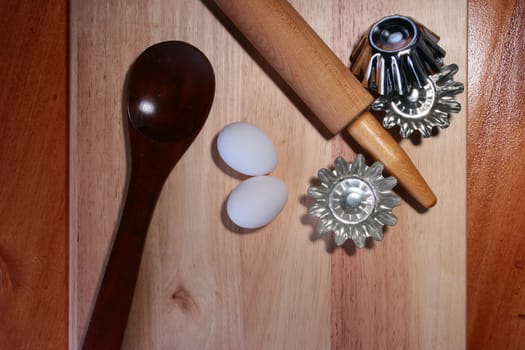 Rolling pin, two eggs, forms for cookies and a wooden spoon.