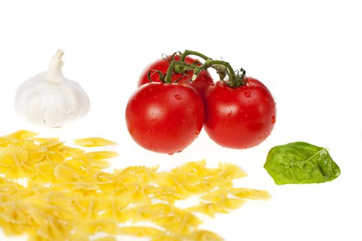 farfalle pasta, tomatoes, garlic and a basil leaf