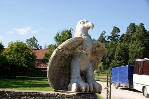 Stone sculpture of an eagle on a background of trees
