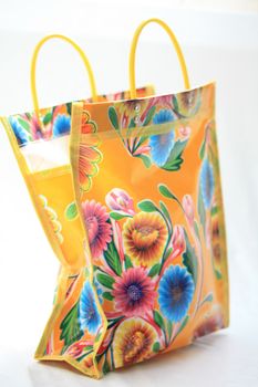 A yellow shopping bag with blue and red flowers