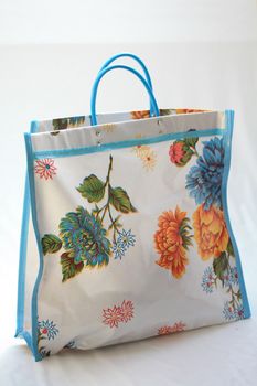 White shopping bag with a floral pattern and blue piping