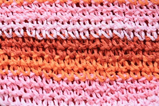 A knitting texture background in pink, orange and red