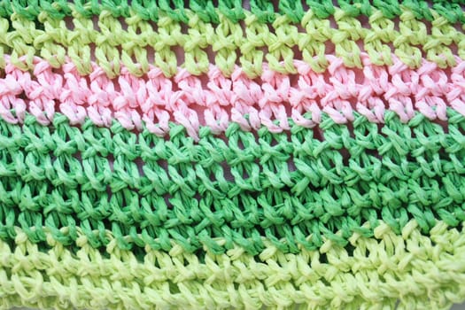 A knitting texture background in different shades of green and pink