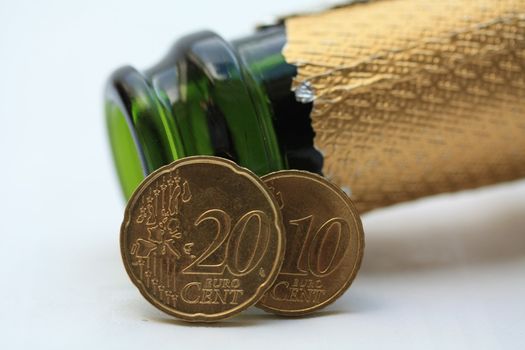 Two euro coins in front of a champagne bottle, happy new year