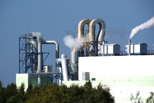 Pipes of a factory on a background of the blue sky