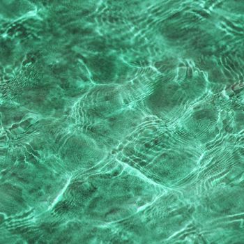 Abstract seamless green texture formed by a sunlight on a water surface