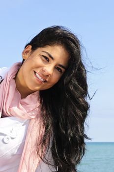 Portrait of beautiful smiling brunette girl at beach being playful