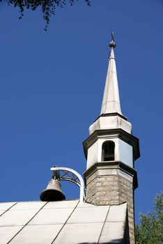 Bell and tower of church on a background of the blue sky