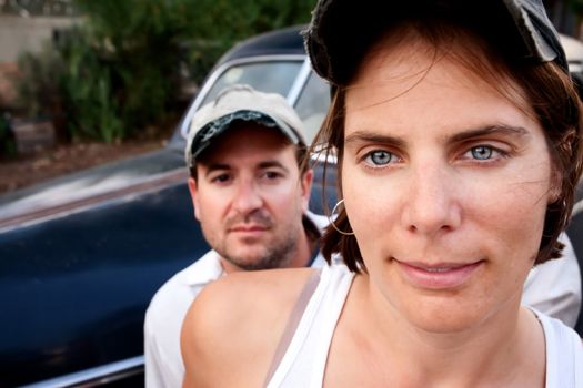 Attractive couple posing with their vintage car