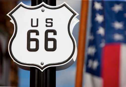 Route 66 sign on side of road with American flag