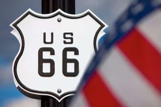 Route 66 sign on side of road with American flag