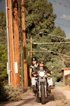 Man and Woman riding motorcyle on dirt road