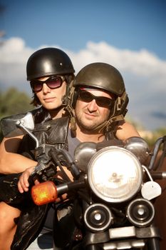 Man and Woman riding motorcyle against Blue Sky