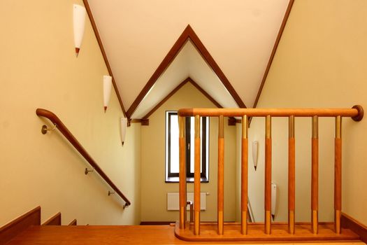 Wooden ladder downwards, a handrail from a file of a tree and a ceiling finished with a tree
