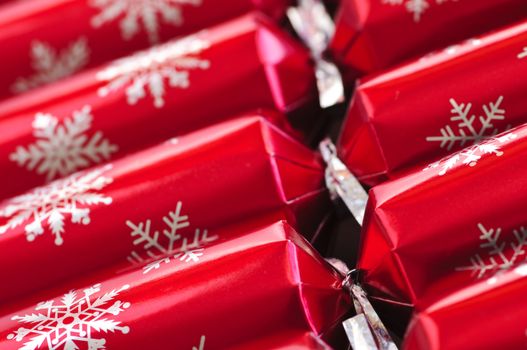 Closeup of many red Christmas crackers in a row