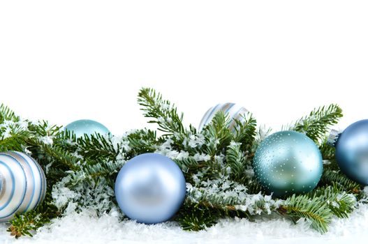 Many Christmas decorations laying in pine branches and snow