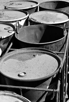 Old rusty 55-gallon fuel barrels corroding outside.