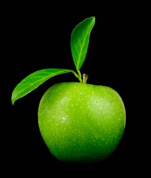Fresh green Granny Smith apple with leaves isolated over black
