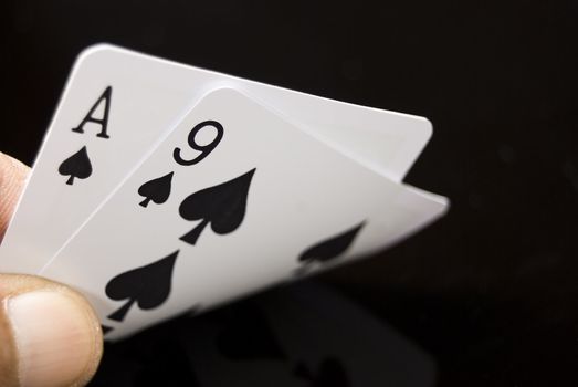Lucky Nine cards held by hand against black background