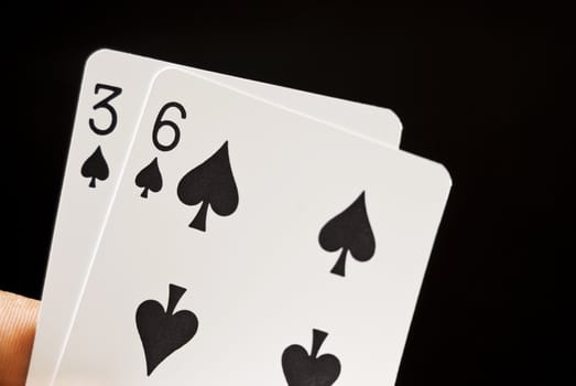 Lucky Nine cards held by hand against black background