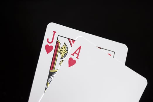 Blackjack cards held by hand against black background