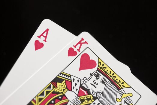 Blackjack cards held by hand against black background