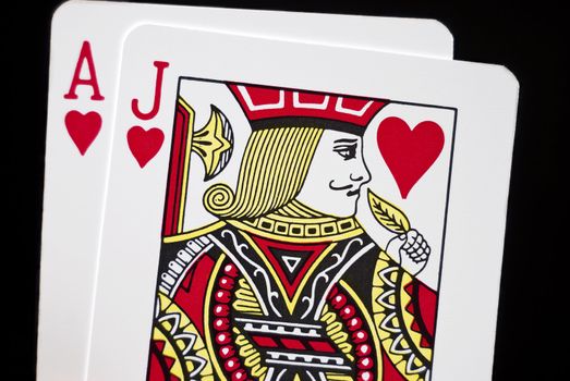 Blackjack cards held by hand against black background