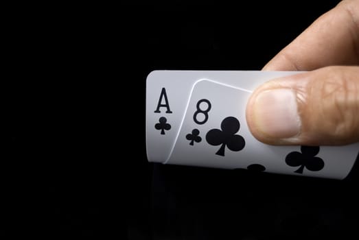 Lucky Nine cards held by hand against black background