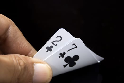 Lucky Nine cards held by hand against black background