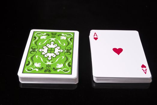 Deck of cards against black background; Ace of Hearts right side up