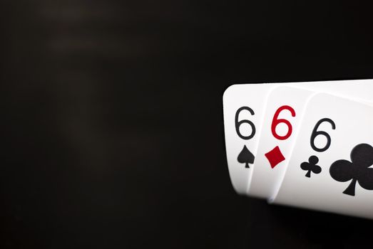 Three sixes against black background