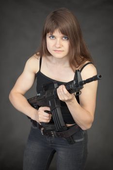 The beautiful young sexual woman - soldier with a rifle in hands
