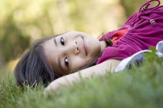 Little girl lying on grass lawnsmiling