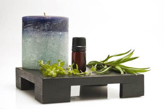 Still life of herbs, mineral oil, and candle