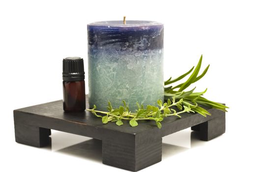 Still life of herbs, mineral oil, and candle