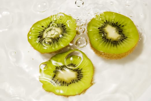 Three slices of kiwi fruit in water