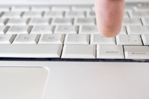 Finger of adult on computer keyboard