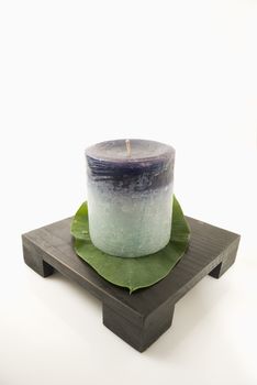 Still life of candle and leaf on candlestand