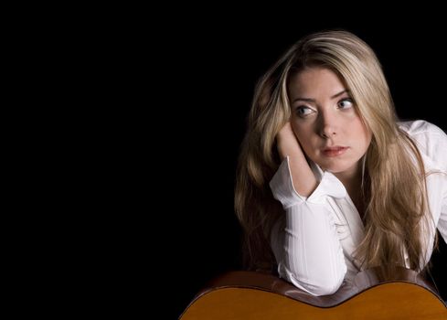 Guitarist hand in hair, elbow on guitar and gazing off into space