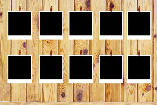 set of ten old blank polaroids frames lying on a wood surface 