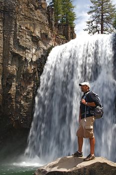 Rugged hiker views the wild terrain at Rainbow Falls in the Devils Postpile NM