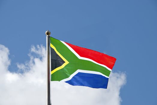 The Flag of South Africa waving in the breeze on a flagpole against a blue sky