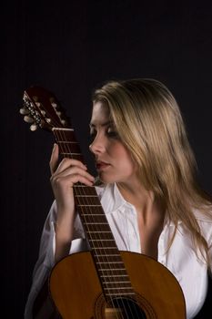 Guitarist leaning against intrument with eyes closed thinking