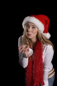 Attractive woman in a santa hat, red boa and over a black background