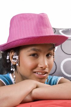 cute african american girl resting head on hands and pink hat on head