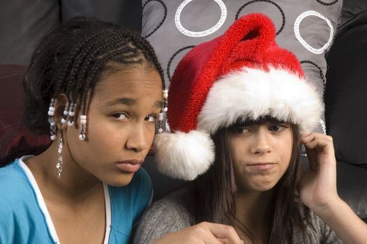 Attractive young girl in a santa hat with african american girlfriend