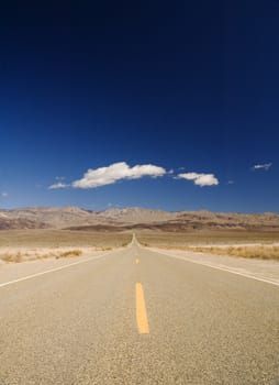 clouds over a very straight road in Death Valley