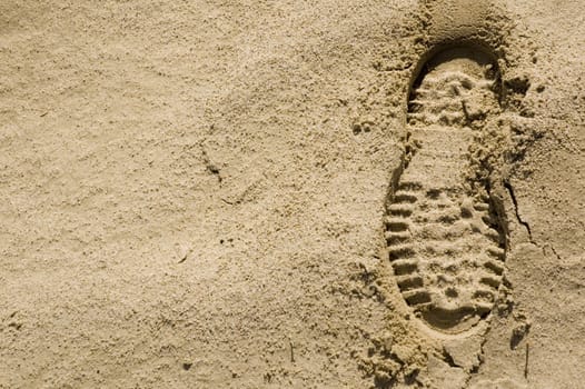 single footprint impression in the desert sand on right of image